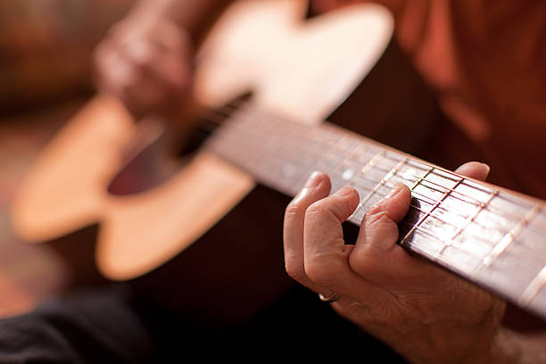 Musician playing acoustic guitar 1 - horizontal stock photo