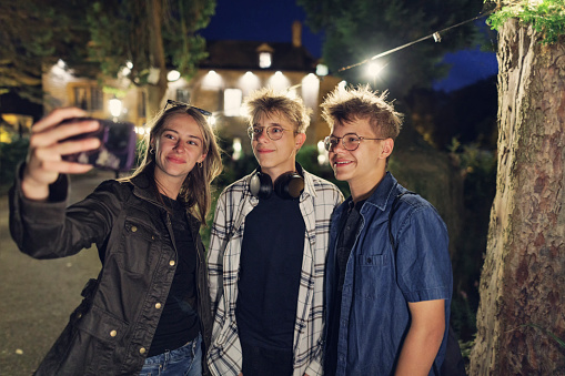 Teenagers are sightseeing Stow-on-the-Wold, a beautiful village in Cotswolds, Gloucestershire, United Kingdom. They are walking a small, charming village streets at night and taking selfies.

Shot with Canon R5