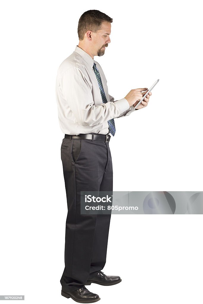 Corporate Man Standing While Using Tablet A white collar worker standing and using an tablet computer tablet. This man could be a corporate person that could deal with insurance, finance, real estate, stock market, restaurant industry, home improvement industry or other industries. Button Down Shirt Stock Photo