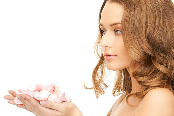 Close-up portrait of a young woman hiding behing a bouquet of pink tulips