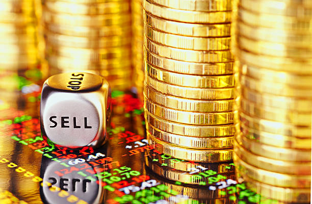 Golden coins, financial chart and dices cube Golden coins, financial chart and dices cube with the word SELL. selective focus goldco ira fees stock pictures, royalty-free photos & images