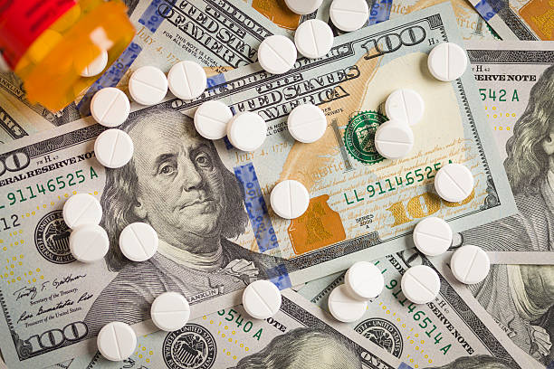 istock Medicine Pills Scattered on Newly Designed One Hundred Dollar Bi 187921849