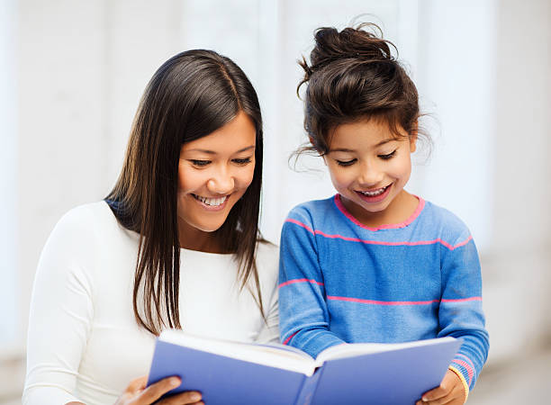 istock mother and daughter with book 187921904