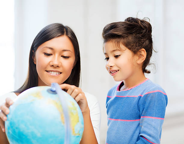 istock mother and daughter with globe 187921910