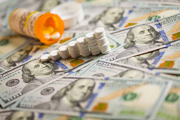 istock Medicine Pills Stacked on Newly Designed One Hundred Dollar Bill 187922044