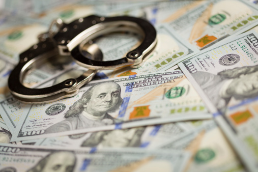 Handcuffs Laying on Newly Designed U.S. One Hundred Dollar Bills.