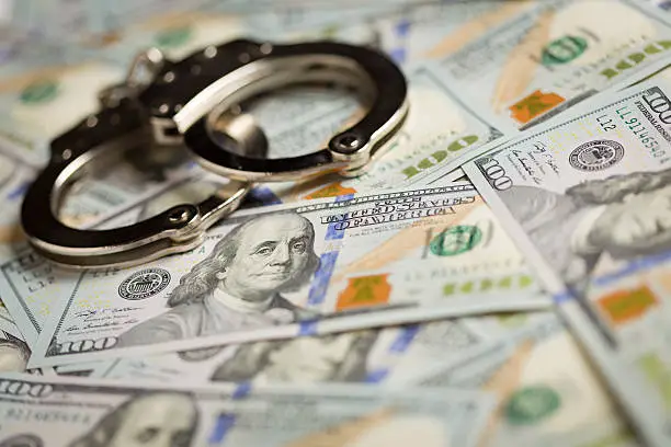 Photo of Handcuffs and Newly Designed One Hundred Dollar Bills