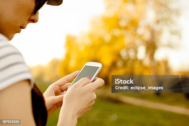 Mujer Joven Usando Un Teléfono Inteligente Al Aire Libre Foto de stock y más banco de imágenes de Adulto