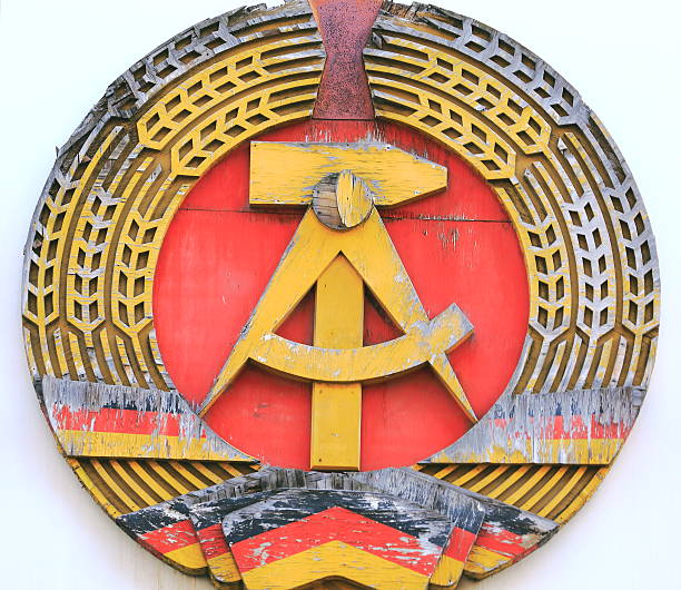 DDR - Symbol of East Germany in bad conditions, at a wall on the street. Berlin, Germany.