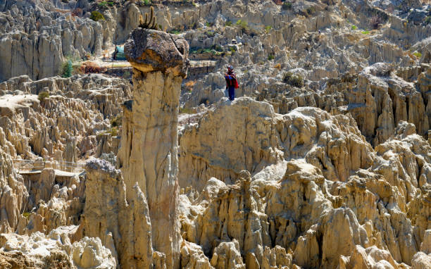 La Paz, Bolivia, October 15, 2023: An indigenous musician plays the flute on a rock formation in the Valle de la Luna outside the city of La Paz.