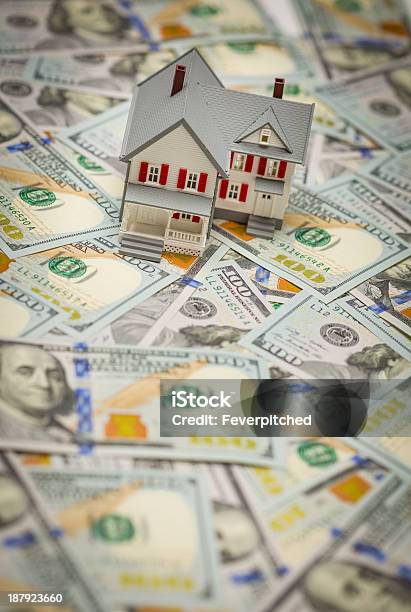 Toy House On Top Of One Hundred Dollar Bills Stock Photo - Download Image Now - Currency, Exploding, House