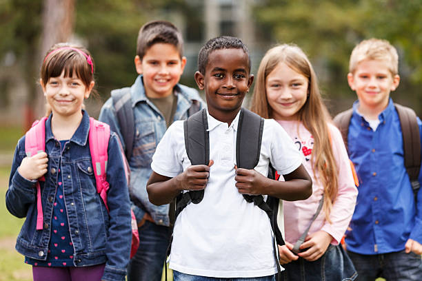 istock School children standing outside with bookbags 187924413