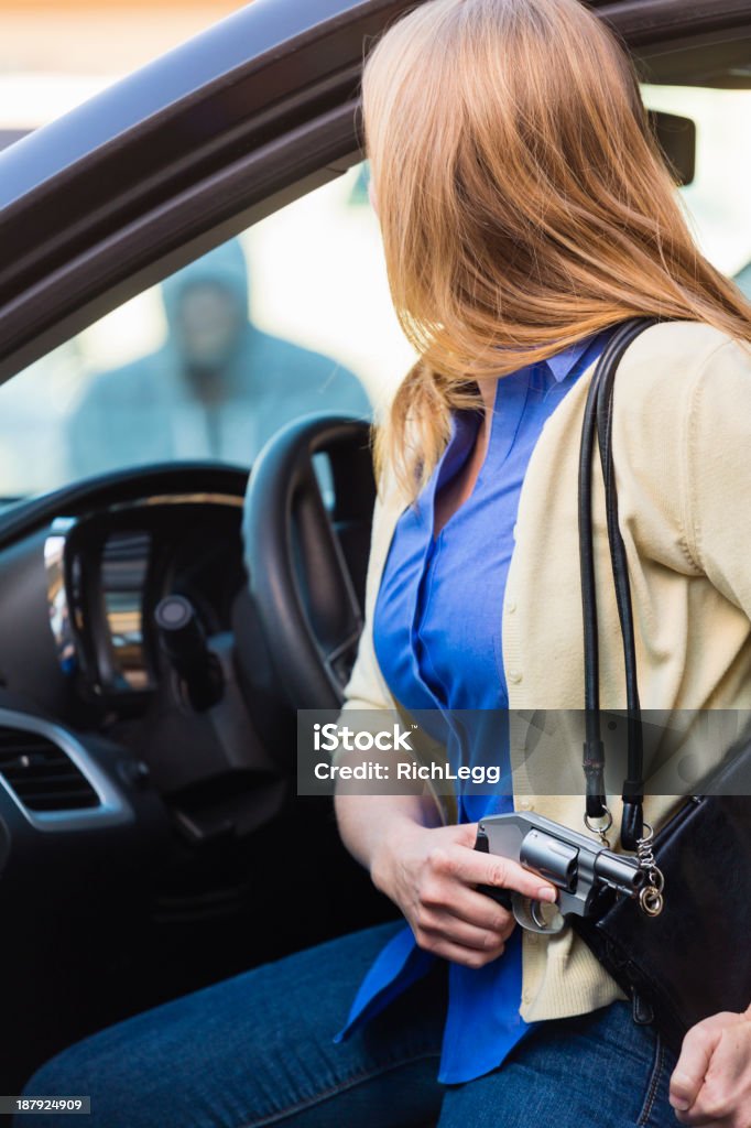 Woman Self-Defense with Handgun A woman in a car holding a handgun for self-defense. Concealed Carry Stock Photo