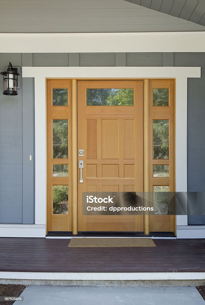 Closed wooden front door of a home Closed wooden front door of a home with gray panels in daytime. Front Door Stock Photo