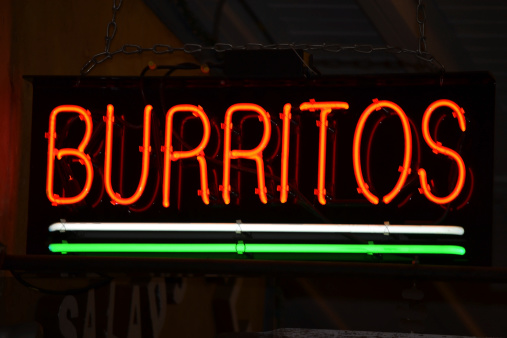 An red neon sign that reads Burritos