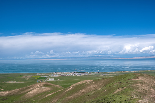Qinghai Lake, grassland, and town under the blue sky and white clouds