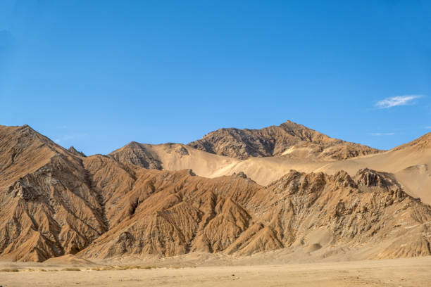 The desolate mountain terrain without plants in a clear sky