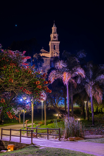 Park of the towns of America and its peculiar lighting with the Sanctuary of Nuestra Señora de la Cabeza in the background and at night Motril.