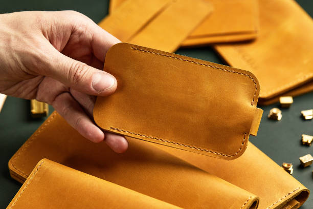 istock Handmade leather goods, close-up. Space for the text, the master jerks a leather block in his hands with a place for the logo. 1879345608