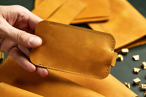 Set of handmade leather goods, key holder rings, wallet, purse, notepad, handbook. Handcrafted leather goods, close-up.
