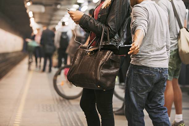 Pickpocketing at the subway station Thief stealing wallet from purse of a woman using mobile phone at the subway station. Pickpocketing at subway station pickpocketing stock pictures, royalty-free photos & images