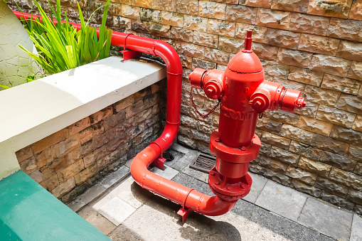 Red colored Hydrant pipe is a fire extinguisher system that is connected to a pressurized water source and distributes water to the extinguishing location. Hydrant for outdoor fire emergency.