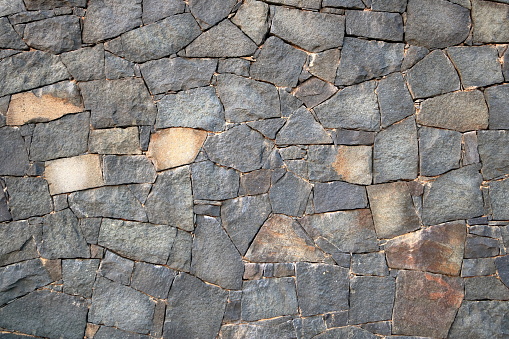 gray natural stone wall of different sized stones, traditional crafts