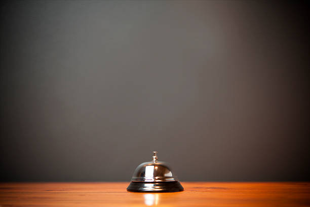 Hotel bell isolated on wooden table stock photo