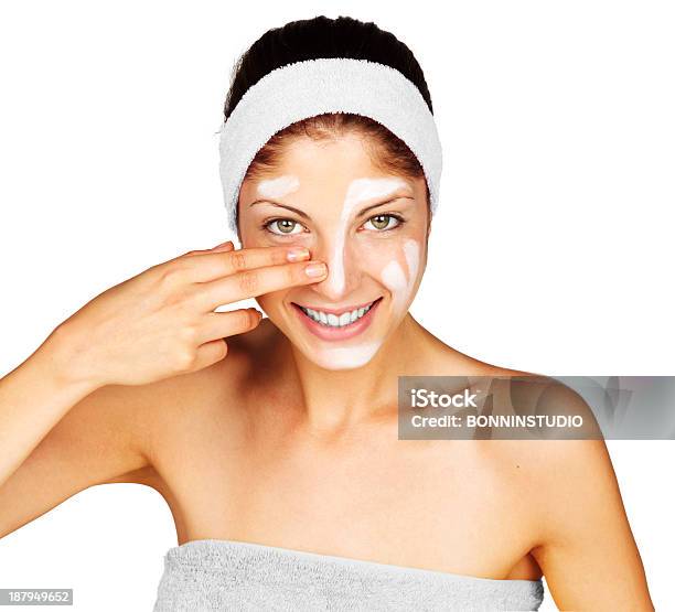 Beautiful Young Woman Applying A Creme On Her Face Stock Photo - Download Image Now