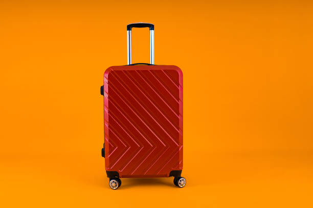istock Red Suitcase on Vibrant Yellow 1879524030