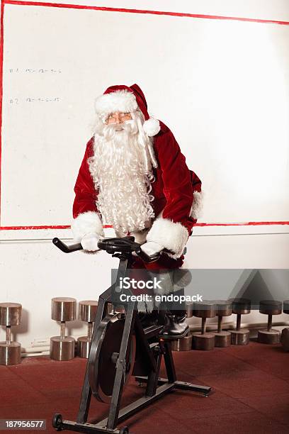 Photo libre de droit de Santa Claus Entraînement Sur Le Vélo Dexercice Dans La Salle De Sport banque d'images et plus d'images libres de droit de Père Noël