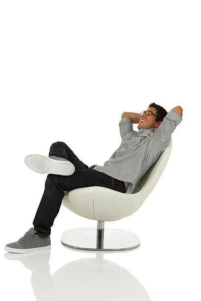 Young Adult Relaxing on chair Young adult relaxing on chair with hands behind head looking up isolated on white man reclining stock pictures, royalty-free photos & images