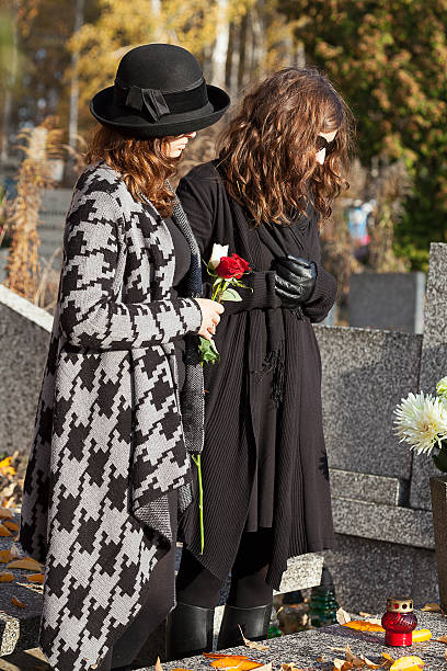 istock Women in mourning at cemetery during autumn 187956787