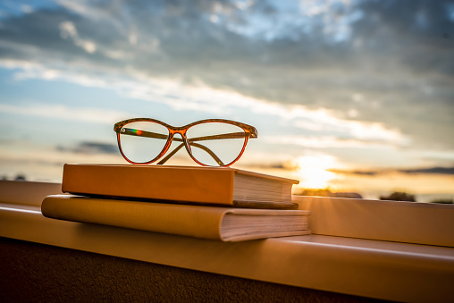 Glasses on a books in the sunset. Relaxing concept.