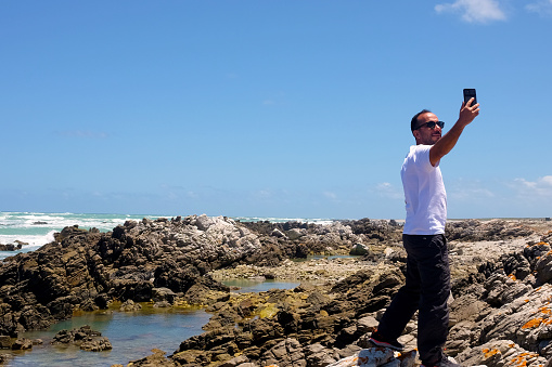 Selfie on Cape Agulhas, cape that is the southernmost point of the African continent, located 109 miles southeast of Cape Town