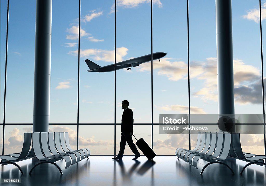 Businessman traveling alone at empty airport businessman in airport and airplane in sky Adult Stock Photo