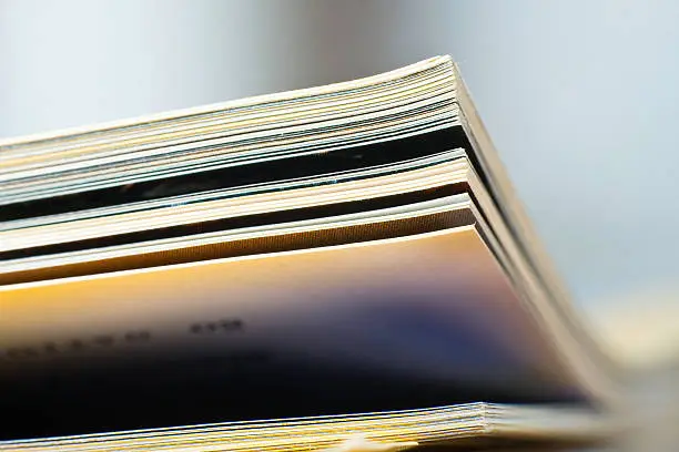 Close-up of magazine pages. Shallow DOF, focus on edges.