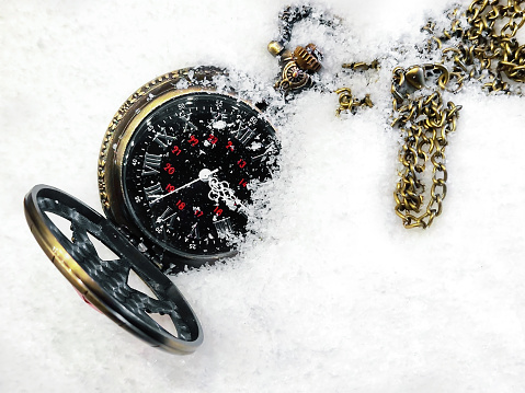 Old watch with chain in the snow