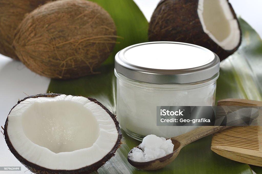 Coconuts and organic coconut oil Coconuts and organic coconut oil in a glass jar on white background. Hair treatment. Coconut Oil Stock Photo