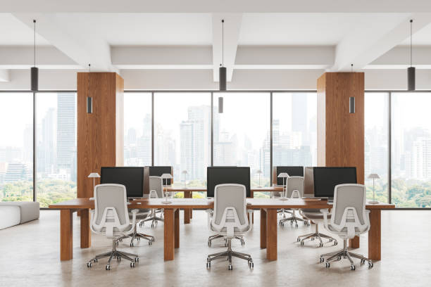 istock Cozy business interior with pc monitors and table in row near panoramic window 1879643039