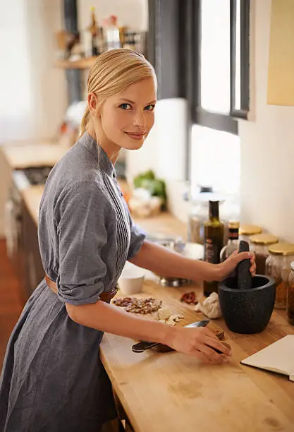 Portrait of an attractive young woman preparing food in a rustic kitchen