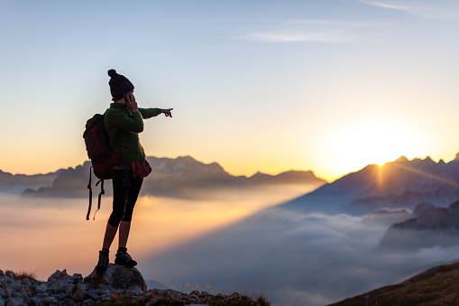Woman Hiker Asking for Direction Navigation Tips trough her Smart Phone from High Mountains of European Alps Summit Remote Location - Mobile Communications Achievements Concept