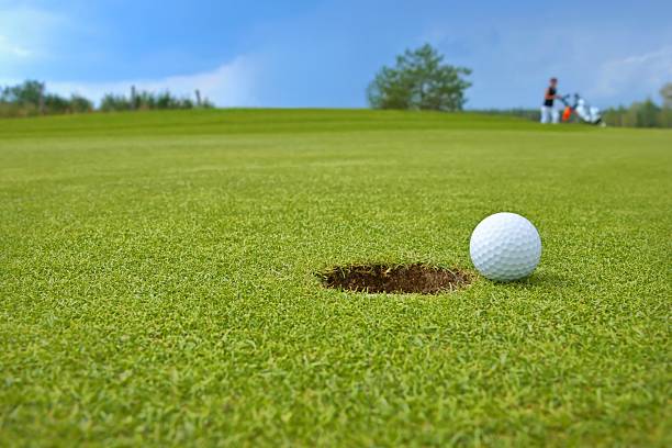 istock Golf, ball lying on the green next to hole 187968401