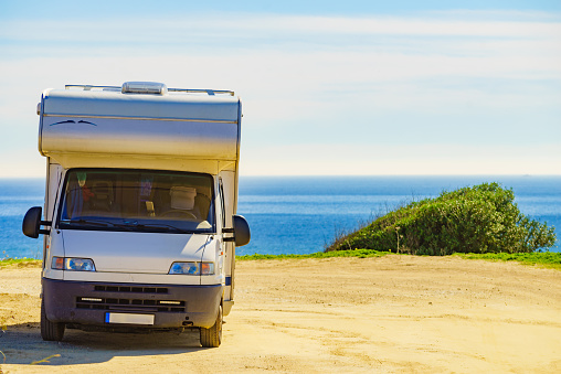 Camper rv caravan on mediterranean coast in Spain. Wild camping on sea shore. Holidays trip with motor home.