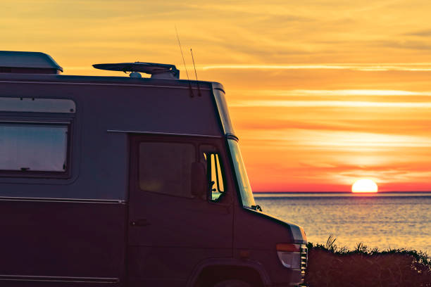 istock Camper vehicle on beach at sunrise 1879703403
