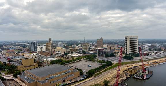Beaumont, Texas USA - December 23, 2023: Aerial view of the Downtown Cityscape and port area of Beaumont Texas with Skyscrapers, Office buildings and an industrial area along the Neches River.