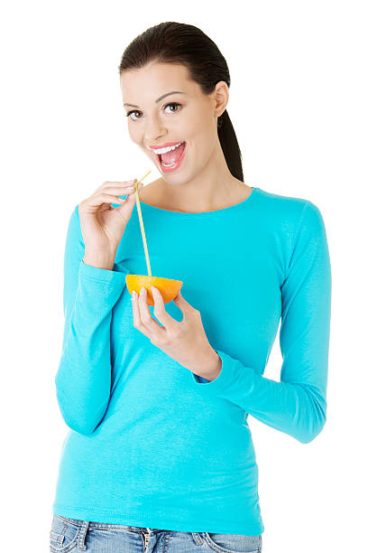 istock Attractive woman drinking juice from orange. 187972385