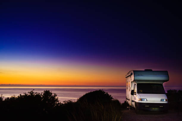 istock Camper vehicle on seashore at sunrise dawn 1879733798