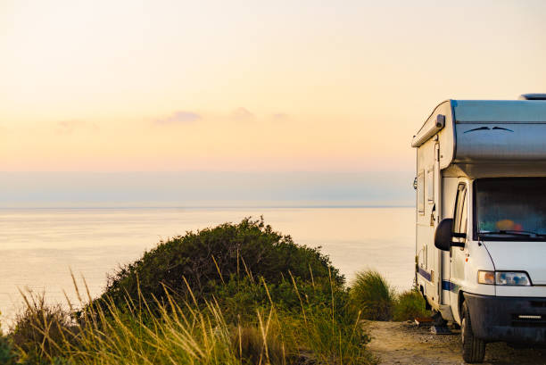 istock Camper vehicle on seashore at sunrise dawn 1879736475