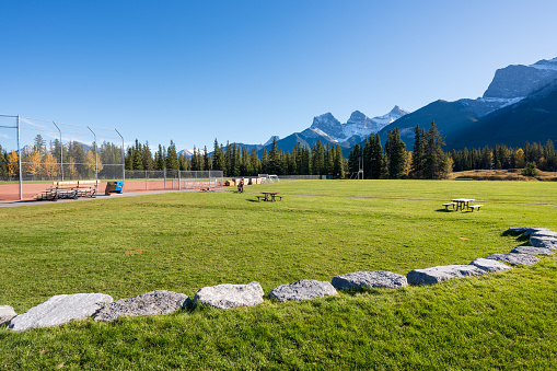Millennium Park Sport Fields & Playgrounds. Canmore, Alberta, Canada. The Three Sisters trio of peaks over the blue sky in the background.